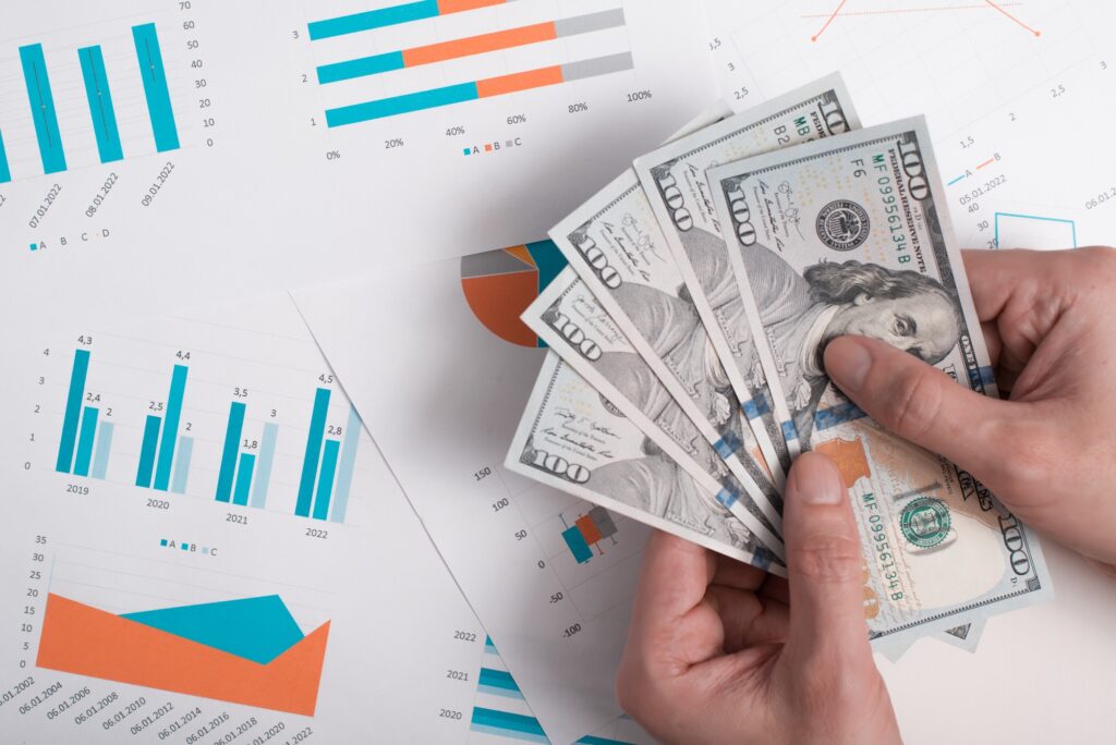 Investment, business and finance concept. Top view hands holding money, documents with graphs